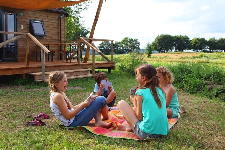 Spelende kinderen voor een accommodatie in de natuur