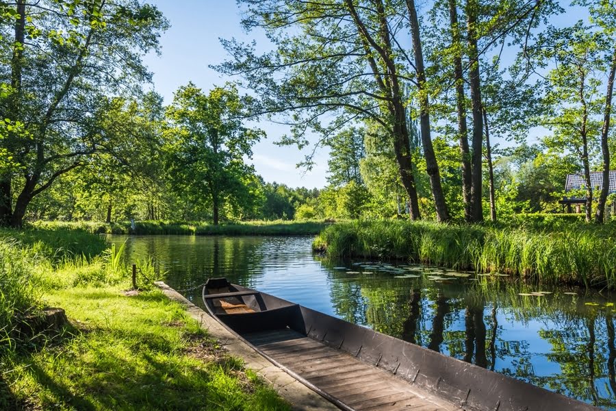 een bootje ligt aan de kade op een waterweg in de natuur