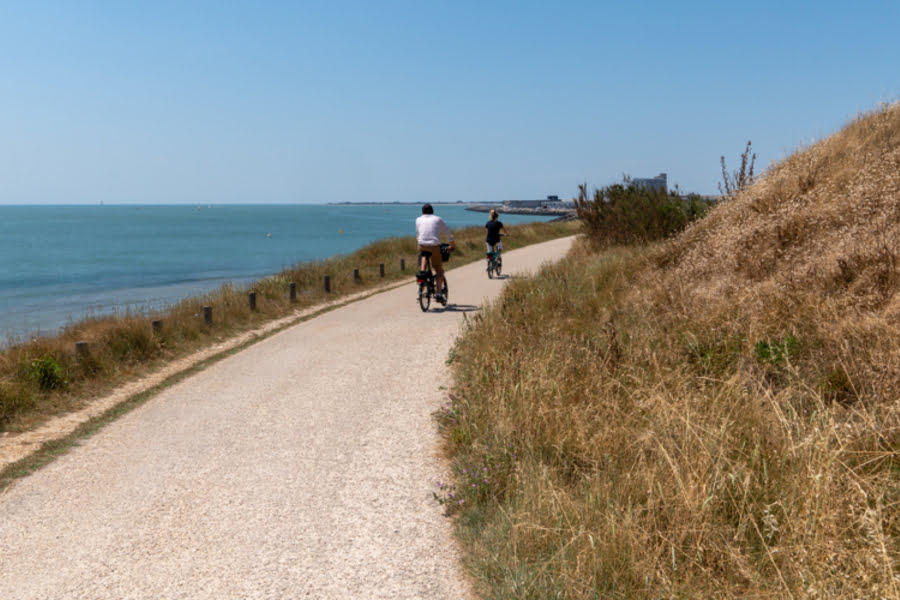 twee mensen fietsen door de duinen langs zee