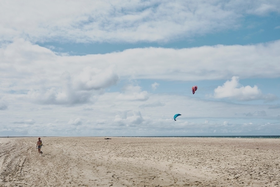 groot strand met kitesurfers in de verte