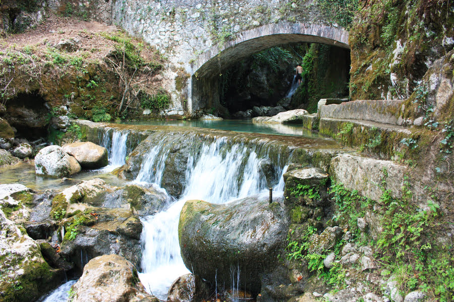 waterval tussen de rotsen, onder een stenen viaduct